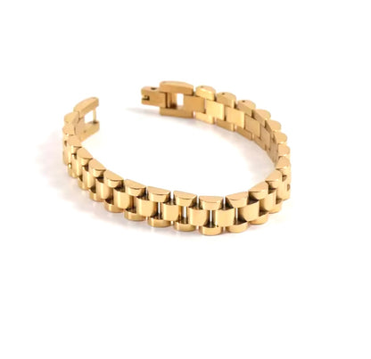 A gold-colored metal cuff bracelet with a secure fastening mechanism.